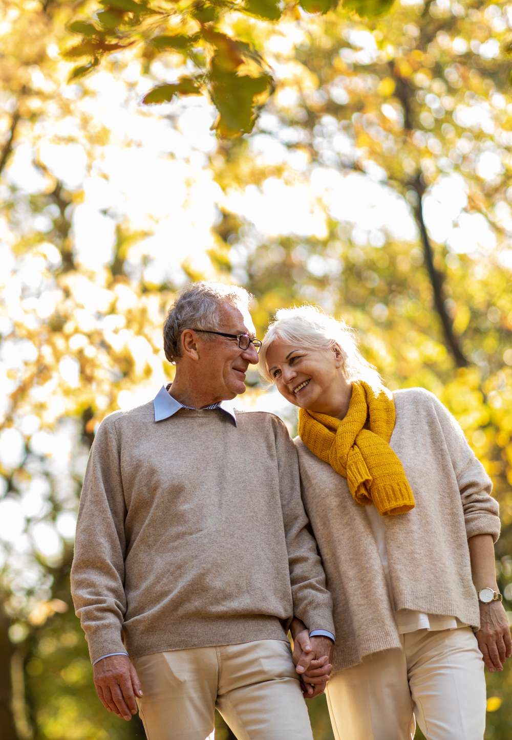 older couple walking in a forest on a fall day